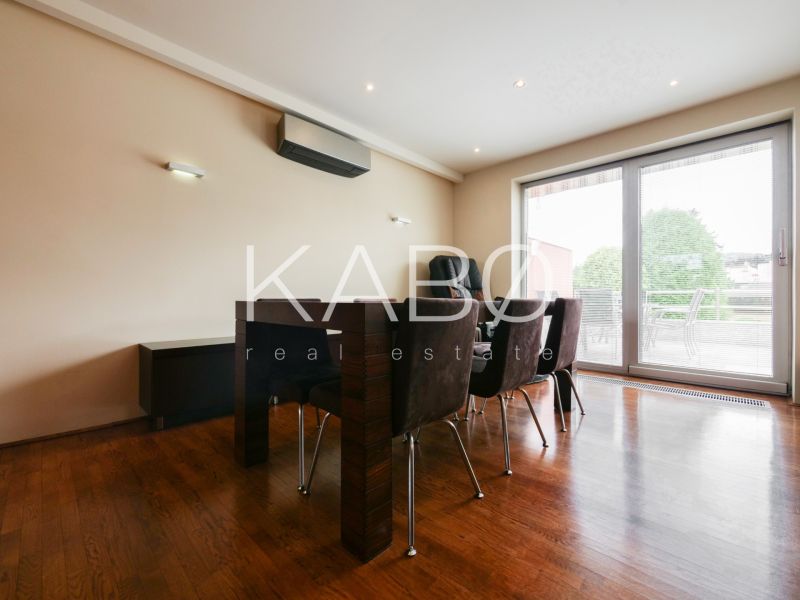 Dining room in a family house with a wood-patterned floor and glass doors to the terrace.