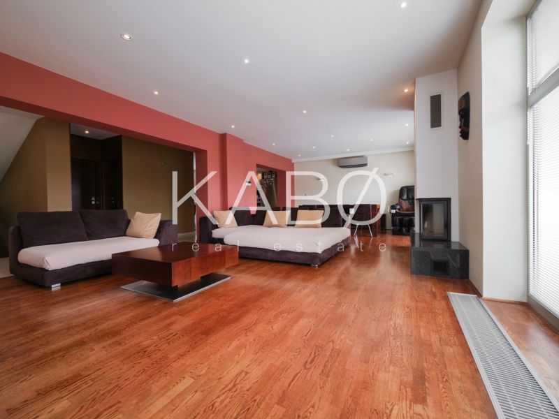 Living room with a fireplace and wood-patterned flooring in a family house.