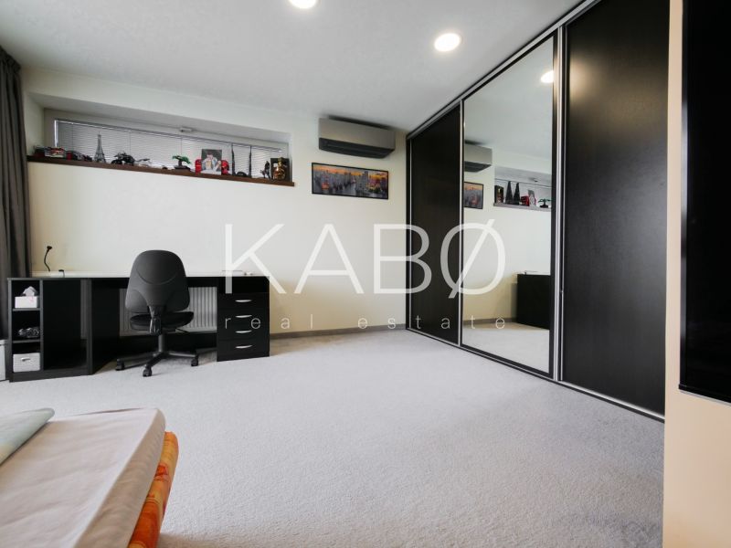 A spacious room with a desk and a large built-in wardrobe in a family house.