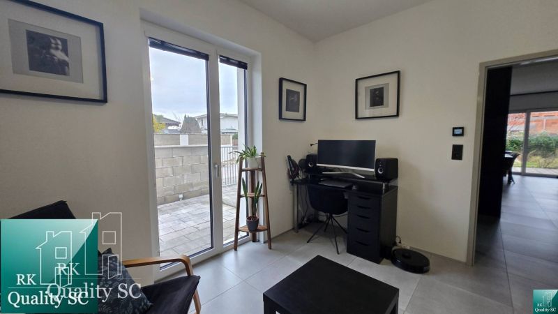 A workspace in a family house with a view of the terrace, wooden decor flooring.