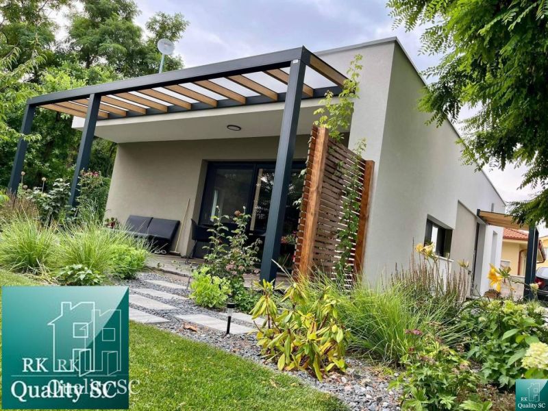 A family house in Senec with a garden and a covered terrace surrounded by greenery.