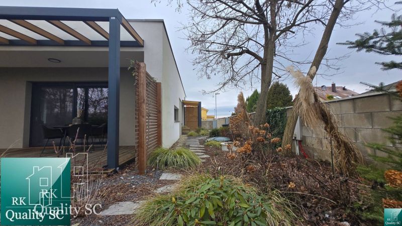 A family house in Senec with a terrace, wooden pergola, and landscaped garden.