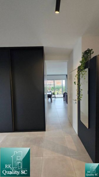 A hallway in a family house with black cabinets leads to the living room.