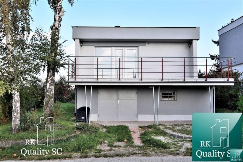 A cottage at SUNNY LAKES SOUTH in Senec with a balcony and surrounding lawn.