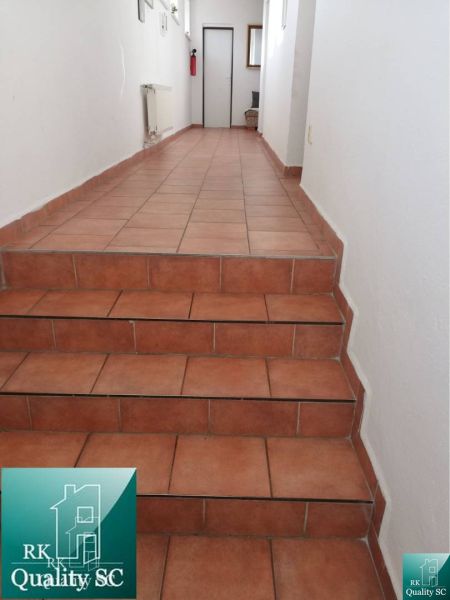 A hallway with ceramic tiles and a staircase in a family house.