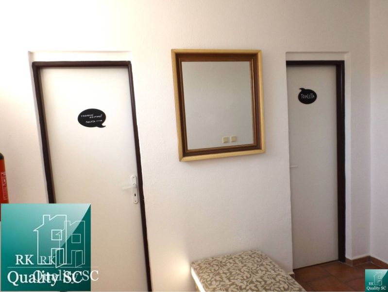 A door in a family house labeled toilet with a mirror on the wall.