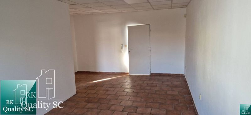 A room in a family house with tiled flooring and white walls.