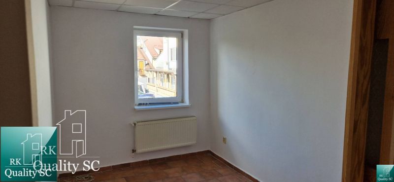 White wall with a window, radiator, and tiles in a family house.