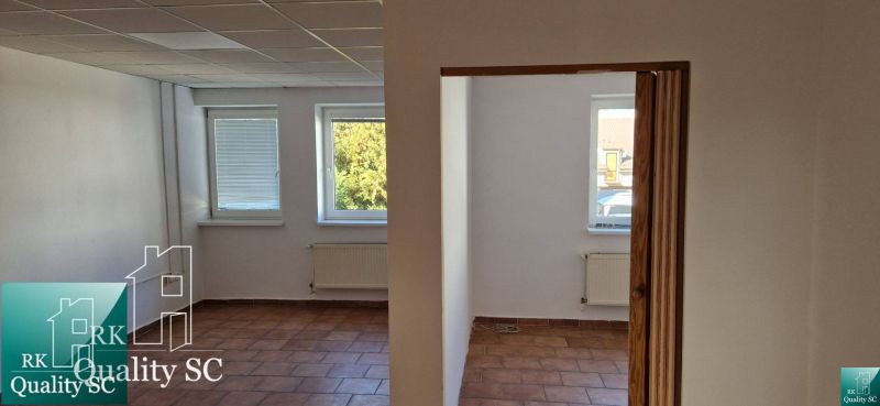 Interior of a family house with terracotta flooring, white walls, and radiators under the windows.