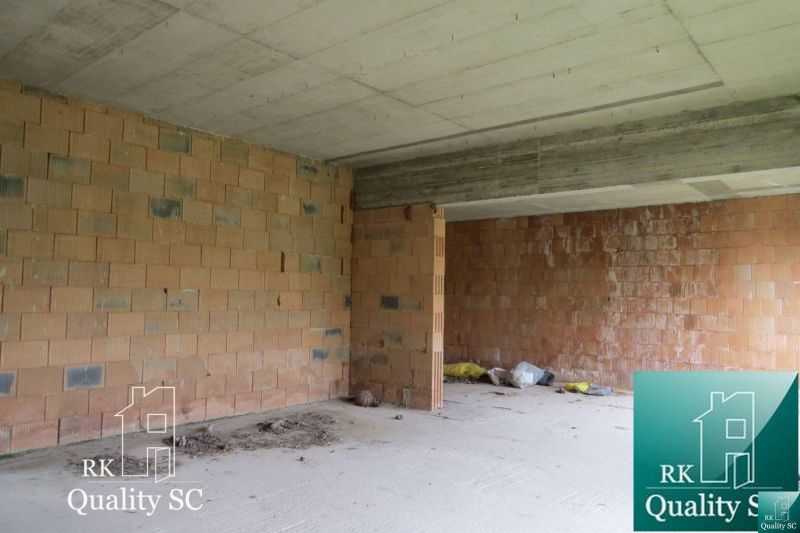 An unfinished interior of a family house with unplastered brick walls.