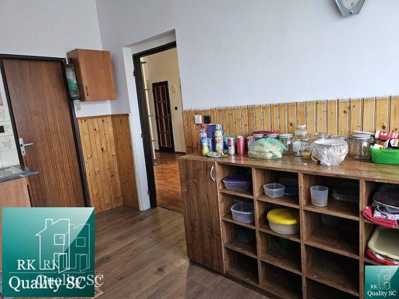 A kitchen with wooden decor in a family house with a pantry and storage spaces.