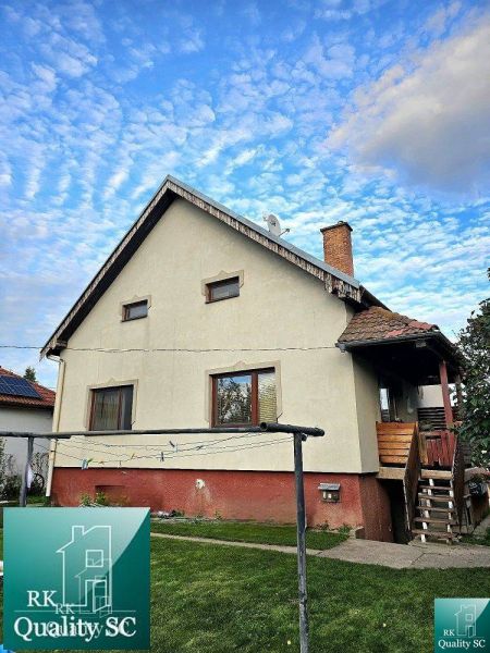 A family house in the town of Tureň on Tureň Street, with a grassy garden and a clothes dryer.