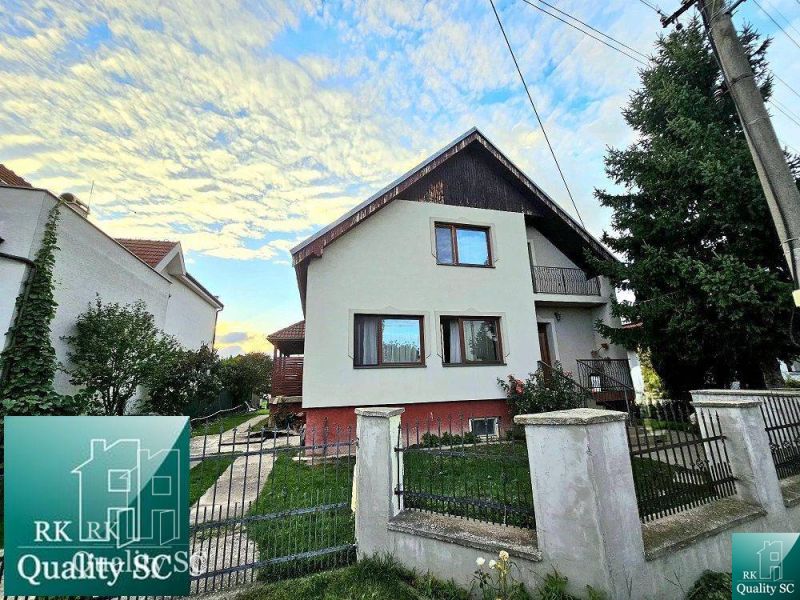 Family house in Turany on Turany Street with a front garden and a fence.