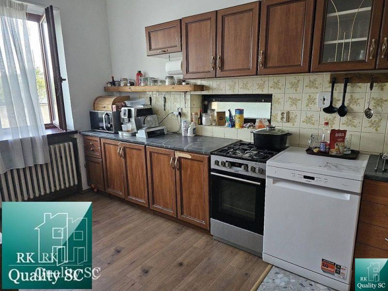 A kitchen in a family house with a wooden decor floor and a kitchen unit.