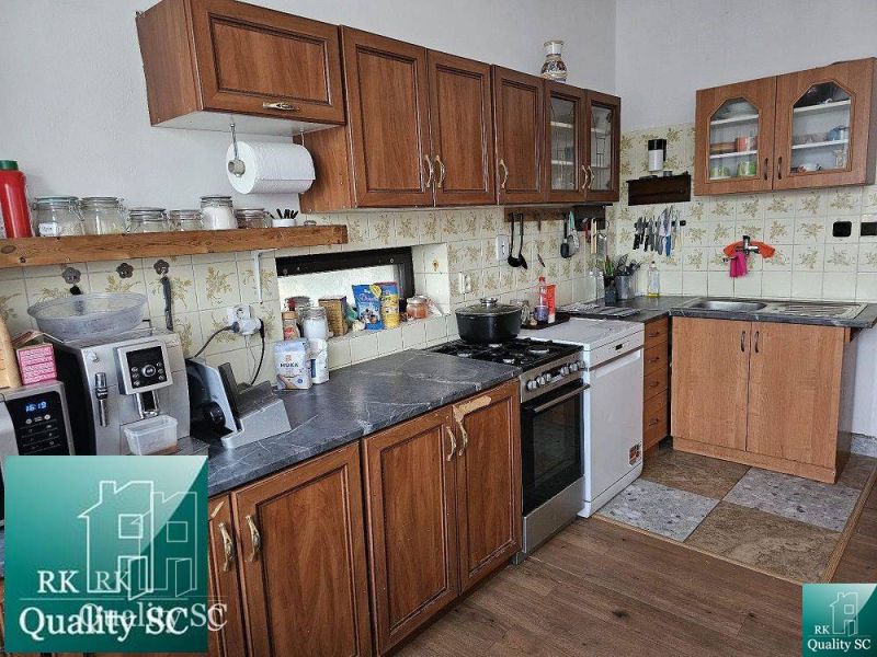 A kitchen in a family house with wooden cabinets and a floor with a wooden decor.