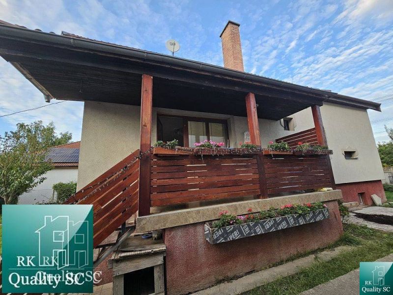 A family house in the village of Tureň with wooden railings and floral decorations on the porch.