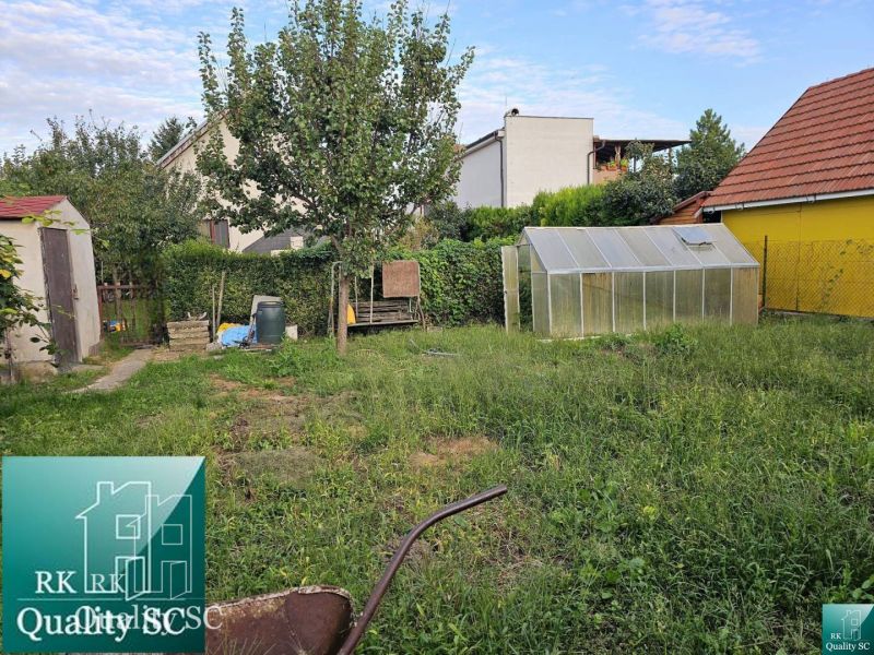 A garden with a gazebo and a greenhouse behind a family house on a street in Turen.