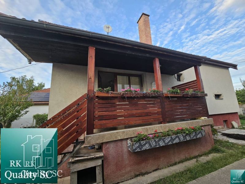 The family house on the street in Turna has a wooden balcony with floral decorations.