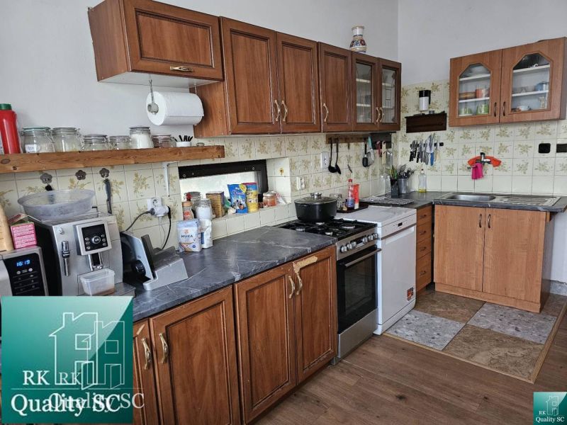 A kitchen in a family house with a wooden floor decor, kitchen units, and appliances.