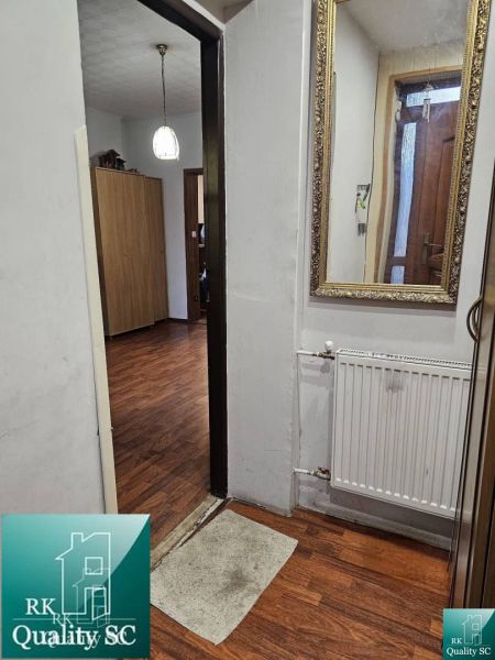 Interior of a family house with a wooden decor floor, mirror, and radiator.