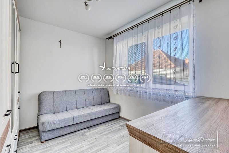 A sofa and cabinets in a room of a family house, with a wooden decor floor.
