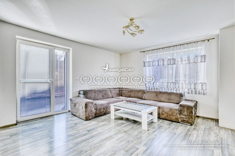 Living room in a family house with a sofa and a table, floor with wooden decor.