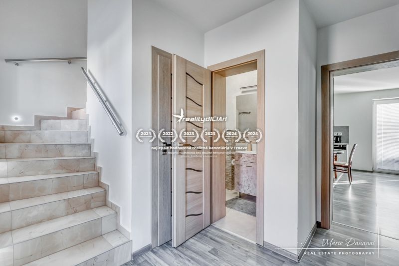 A staircase with marble tiles and a floor with wooden decor in a family house.