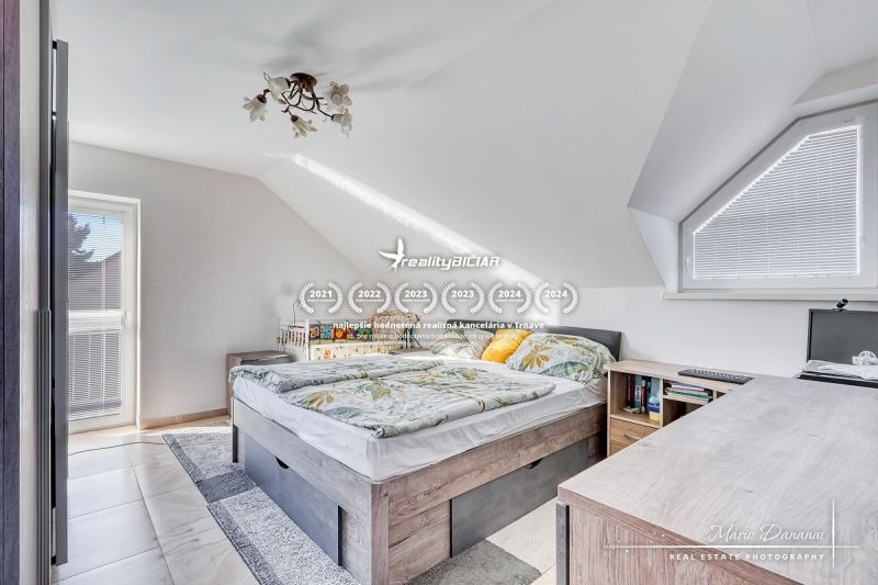 A bright attic bedroom with a comfortable bed and a view, family house.