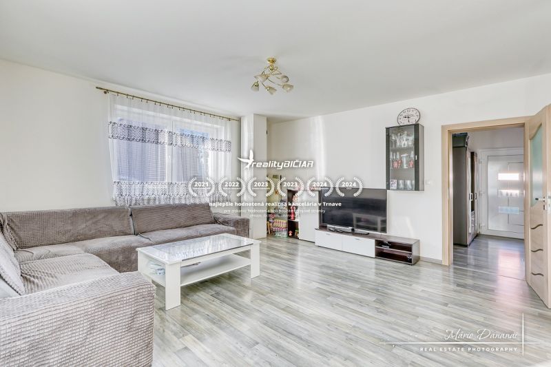 Living room in a family house with a corner sofa and a wooden decor floor.