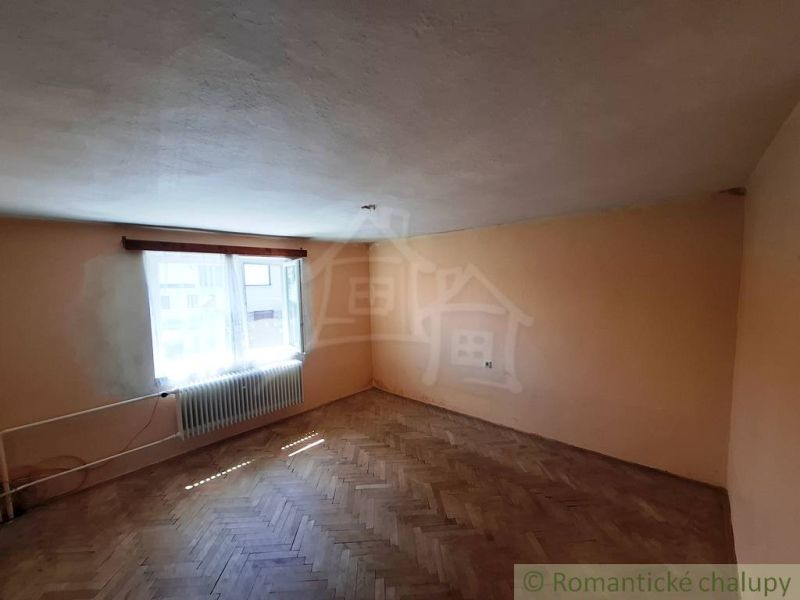 A room with a wooden decor floor and a radiator in a family house.