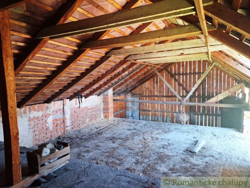 Attic of a family house with wooden beams and brick walls.