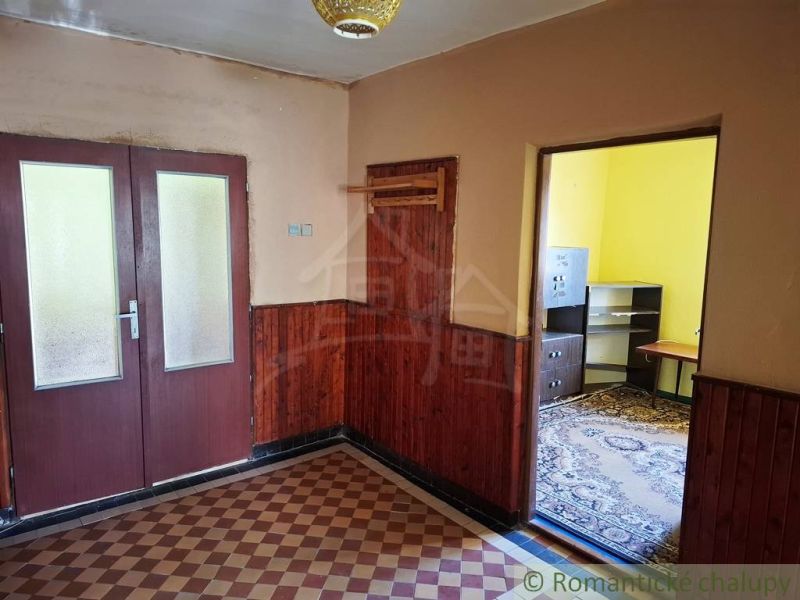 A room in a family house with tiles and furniture in the corner.