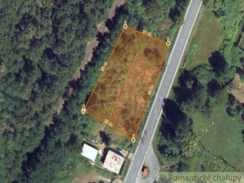 A residential plot by the road in Šiatorská Bukovinka, surrounded by greenery.