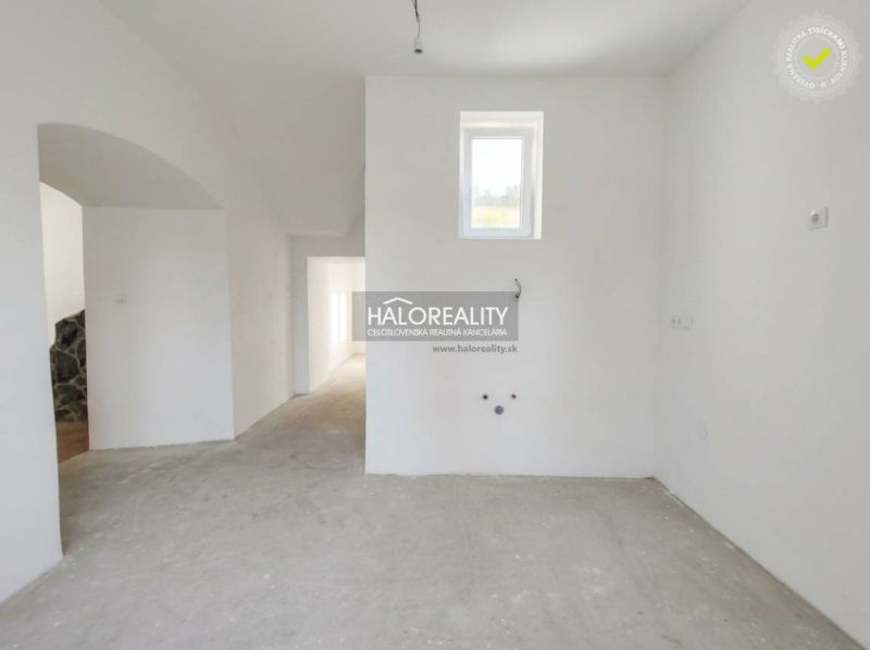 The interior of a spacious 3-room apartment with white walls and a small window.