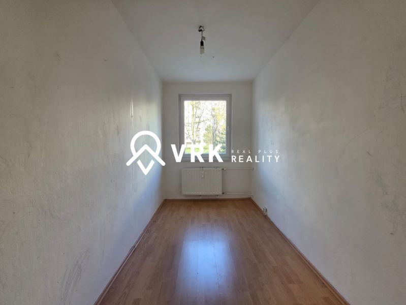 An empty room with a wooden decor floor in a 4-room apartment.