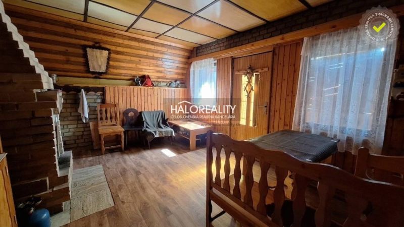 The interior of a cabin with a wooden decor floor and a brick fireplace, cozy atmosphere.
