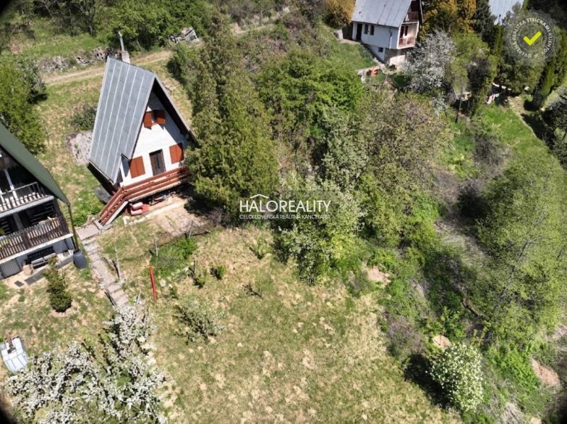 A cottage in Chyžné surrounded by greenery and nearby buildings, ideal for relaxation.