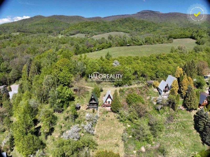 A cottage in Chyžné surrounded by forests and green meadows under a mountain panorama.