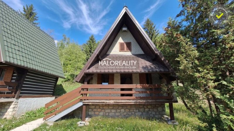 A cottage in Chyžné surrounded by forest and blue sky, suitable for relaxation.