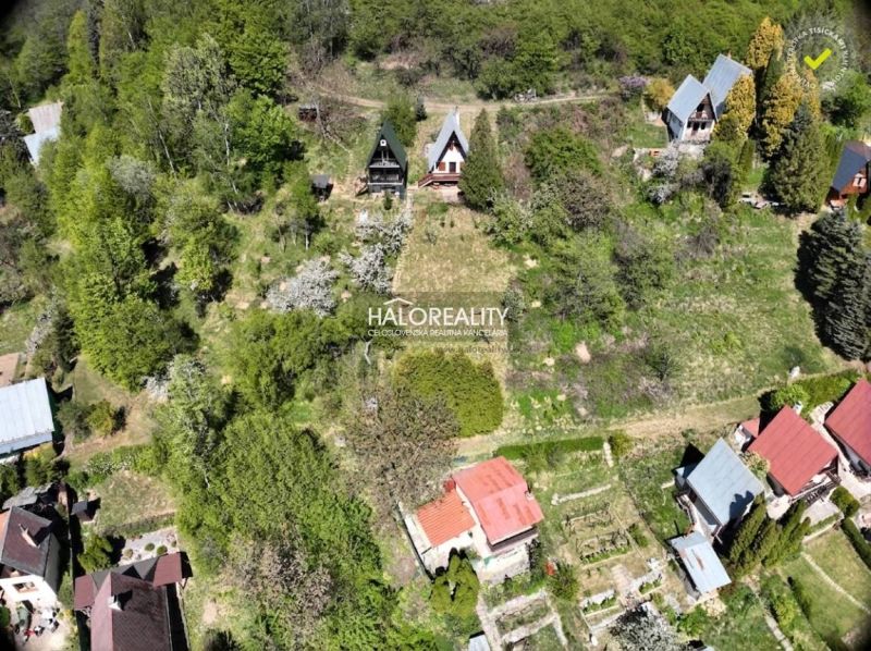 A cottage in Chyžné surrounded by greenery, situated in a spacious garden with surrounding trees.