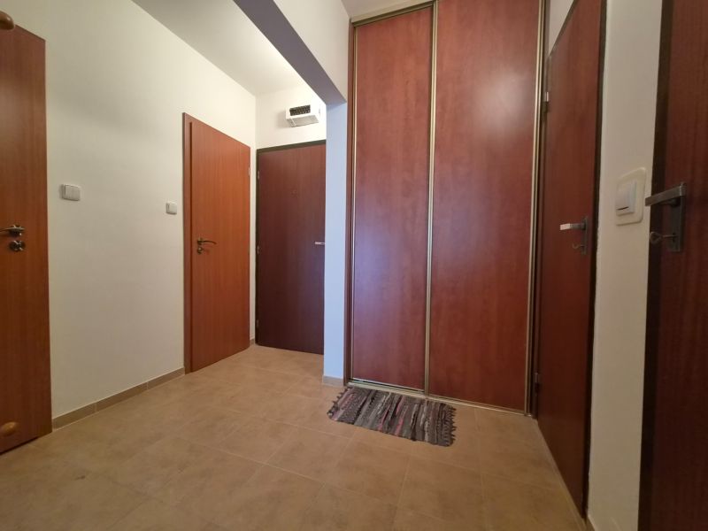 Tiling, wooden doors, and a built-in wardrobe in a 2-room apartment.