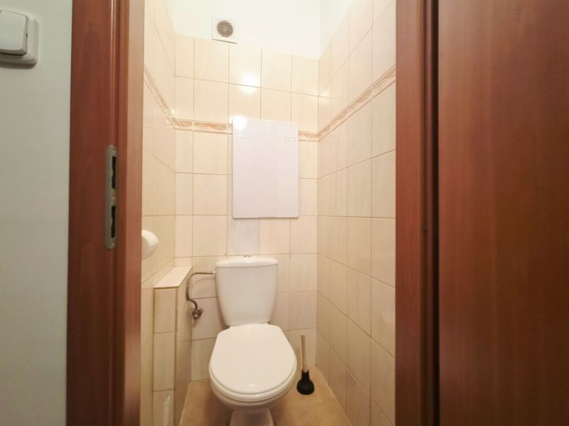 Bathroom in a 2-room apartment with tiles and a toilet.