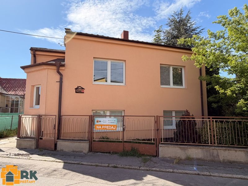 A family house on Mlynska Street in Piešťany with white windows, an orange facade, and a fence.