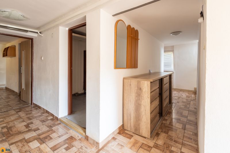 Interior of a family house with a cabinet and a mirror, floor with wooden decor.