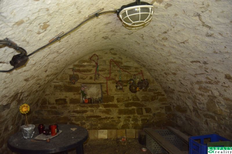 A stone cellar in a family house with a vaulted ceiling and small decoration.