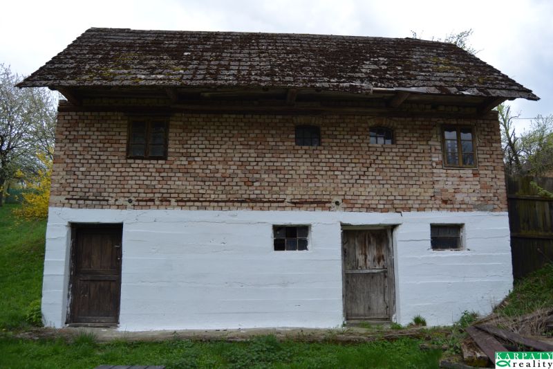 A family house in Bukovec with brick walls and a wooden roof in the countryside.