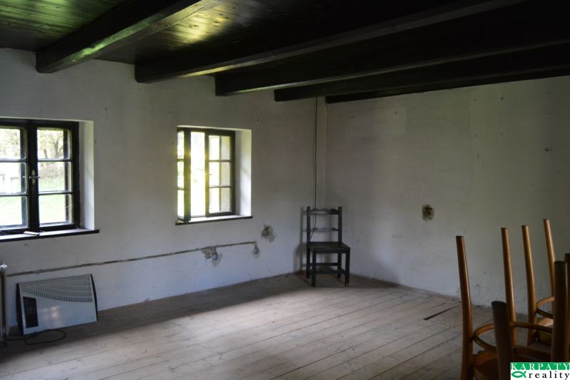 A room in a family house with a wooden decor floor and simple furniture.