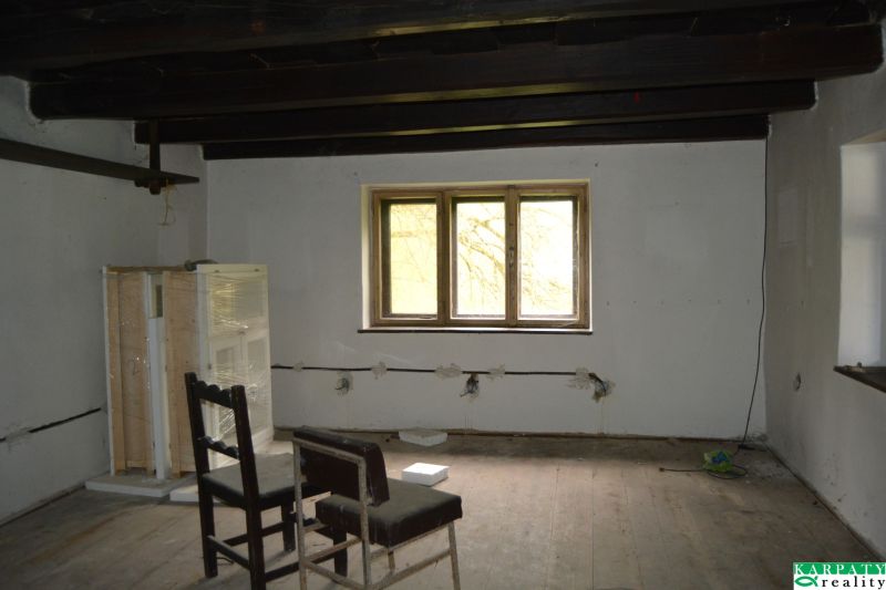 Interior of a family house with a wooden decor floor and a chair under the window.