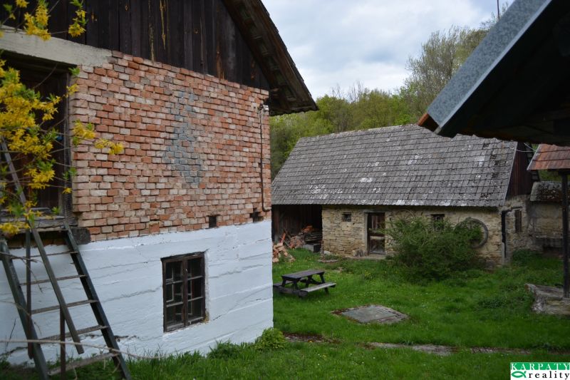 A family house in Bukovec with traditional brick and stone buildings, garden table.