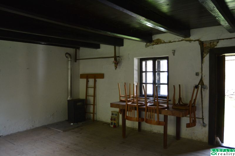 Interior of a family house with a stove, table, chairs, and a floor with a wooden decor.